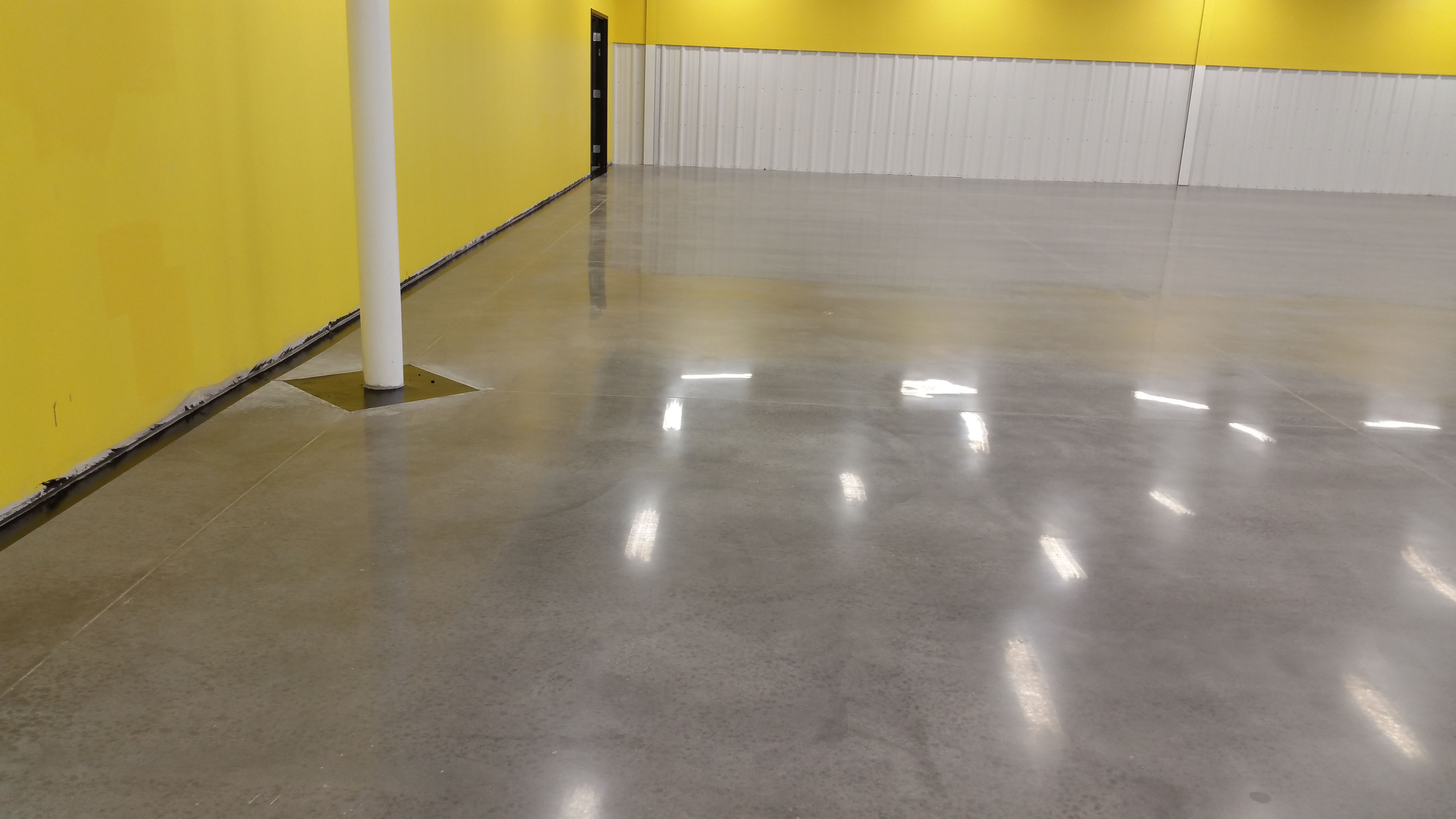 Overhead lights reflect off a polished cement floor.
