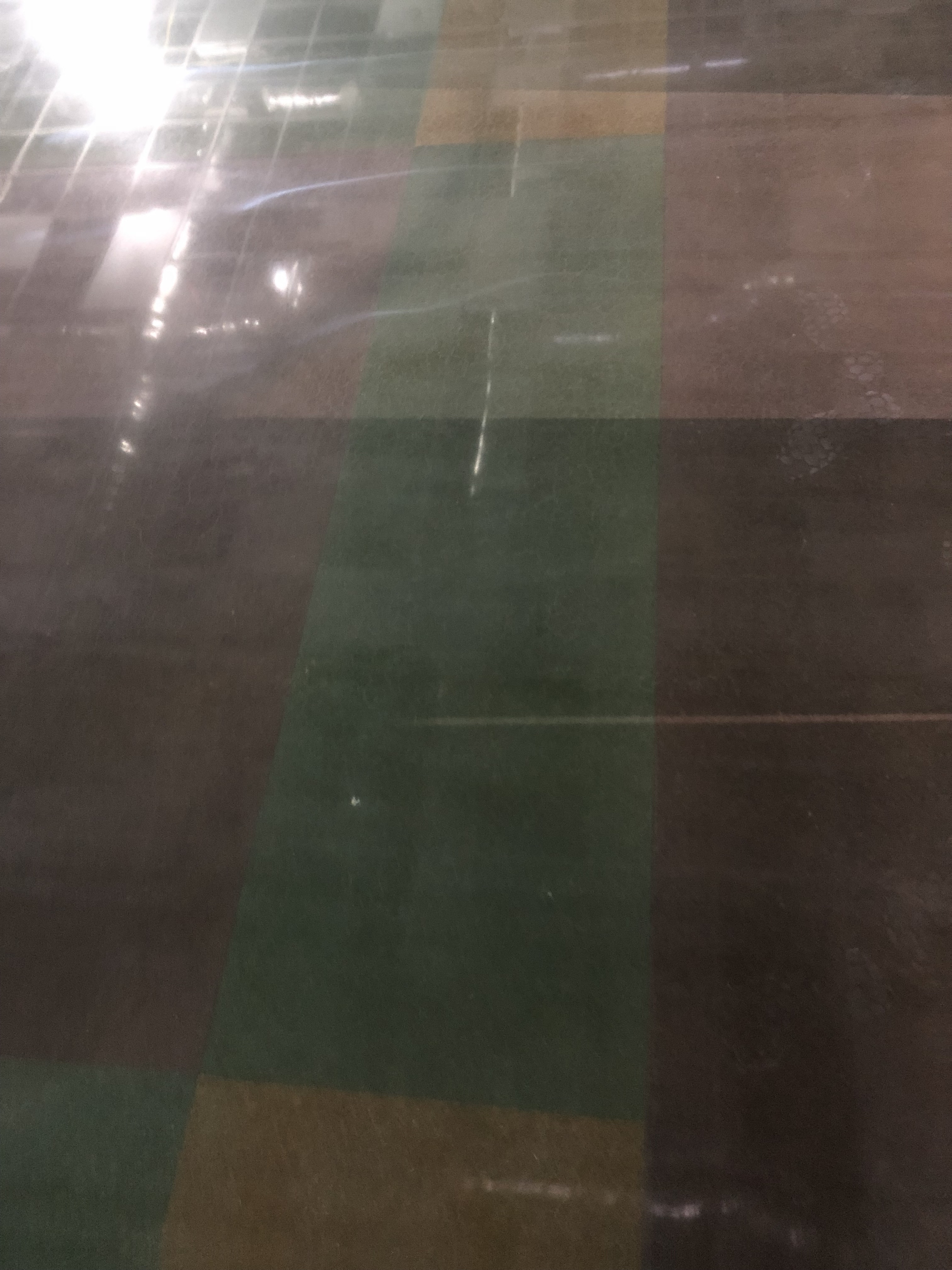 A polished concrete floor demonstrating a red, green, and yellow square pattern.