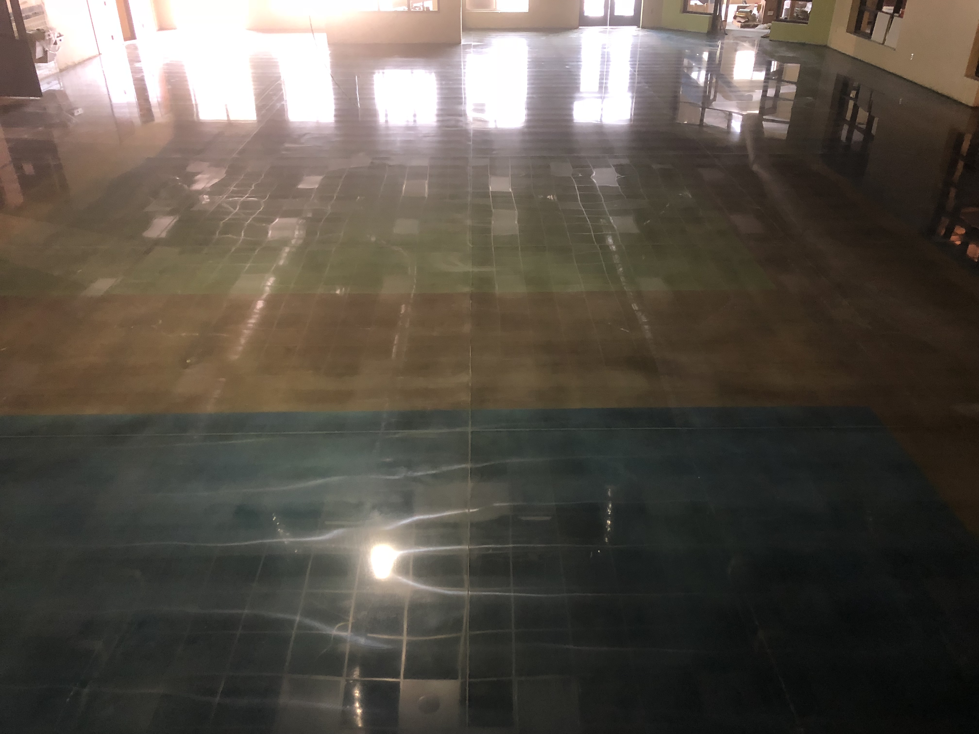Lights reflect off of this gorgeously pattened green and blue concrete floor with a brown seperation