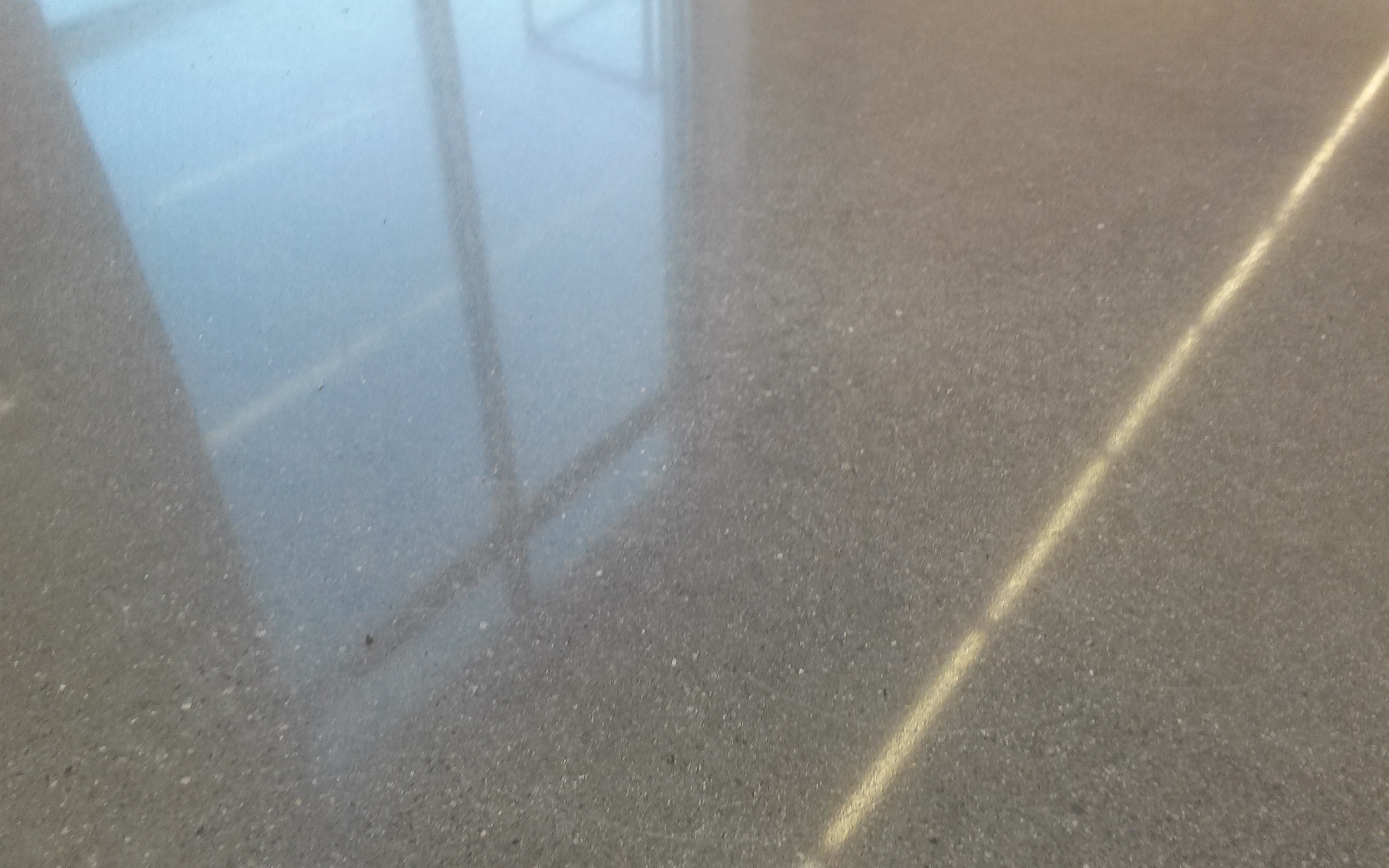 Sunlight from the window reflects off a polished concrete floor.